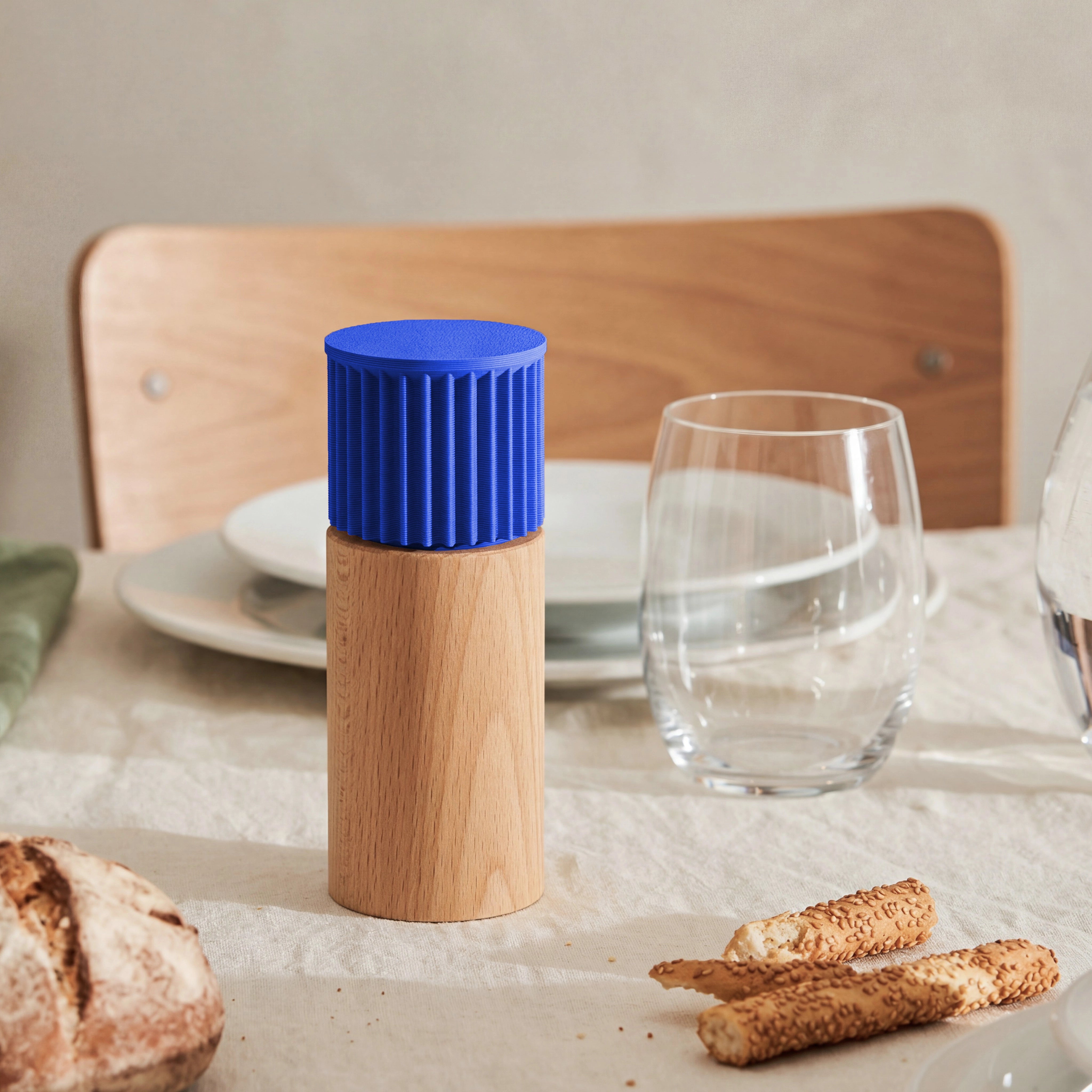 Gewürzmühle Prise in blau aus Buchenholz auf gedecktem Tisch mit Brot und Wasserglas #farbe_blau