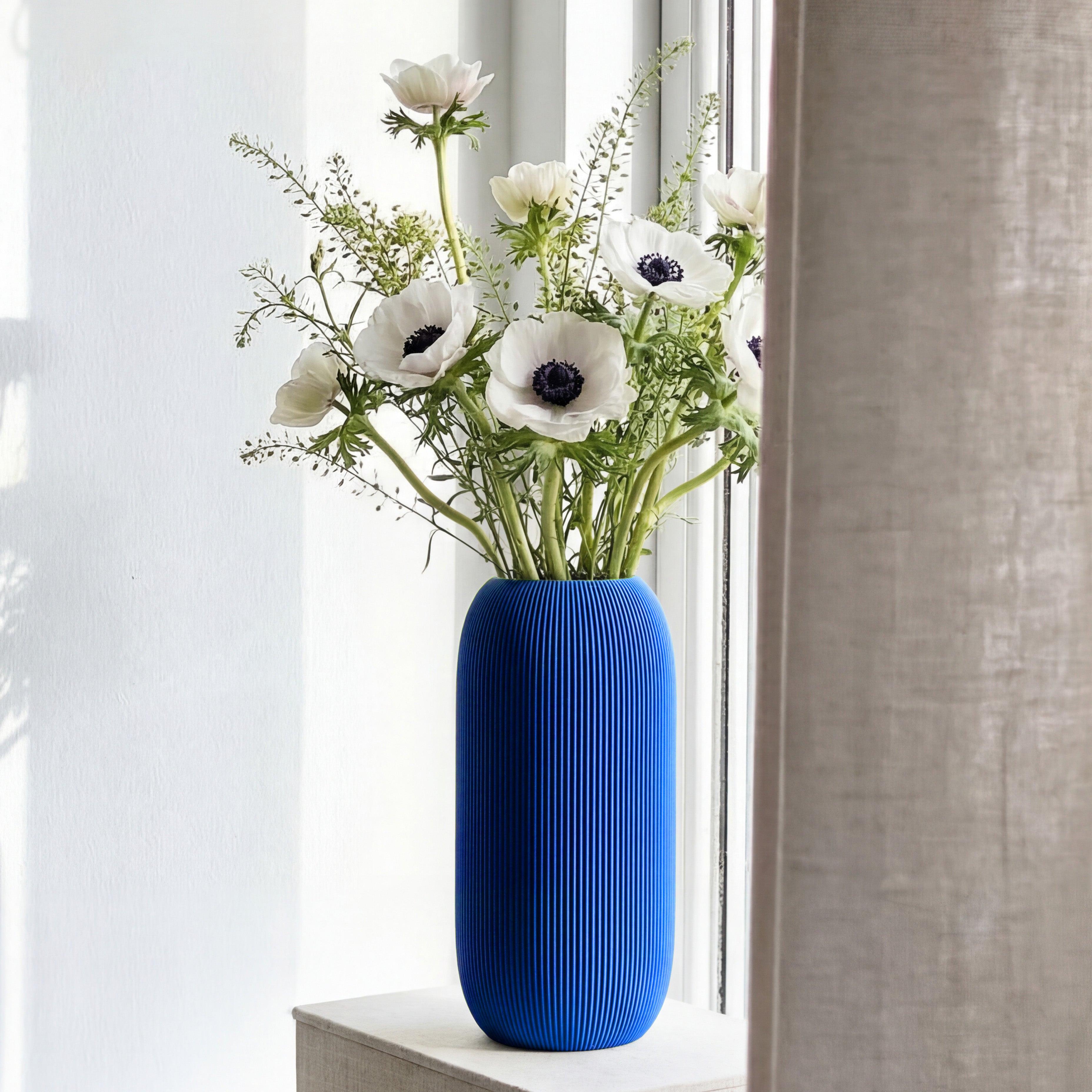 Geriffelte Vase Pille in blau mit weißen Anemonen auf einer Fensterbank #farbe_blau