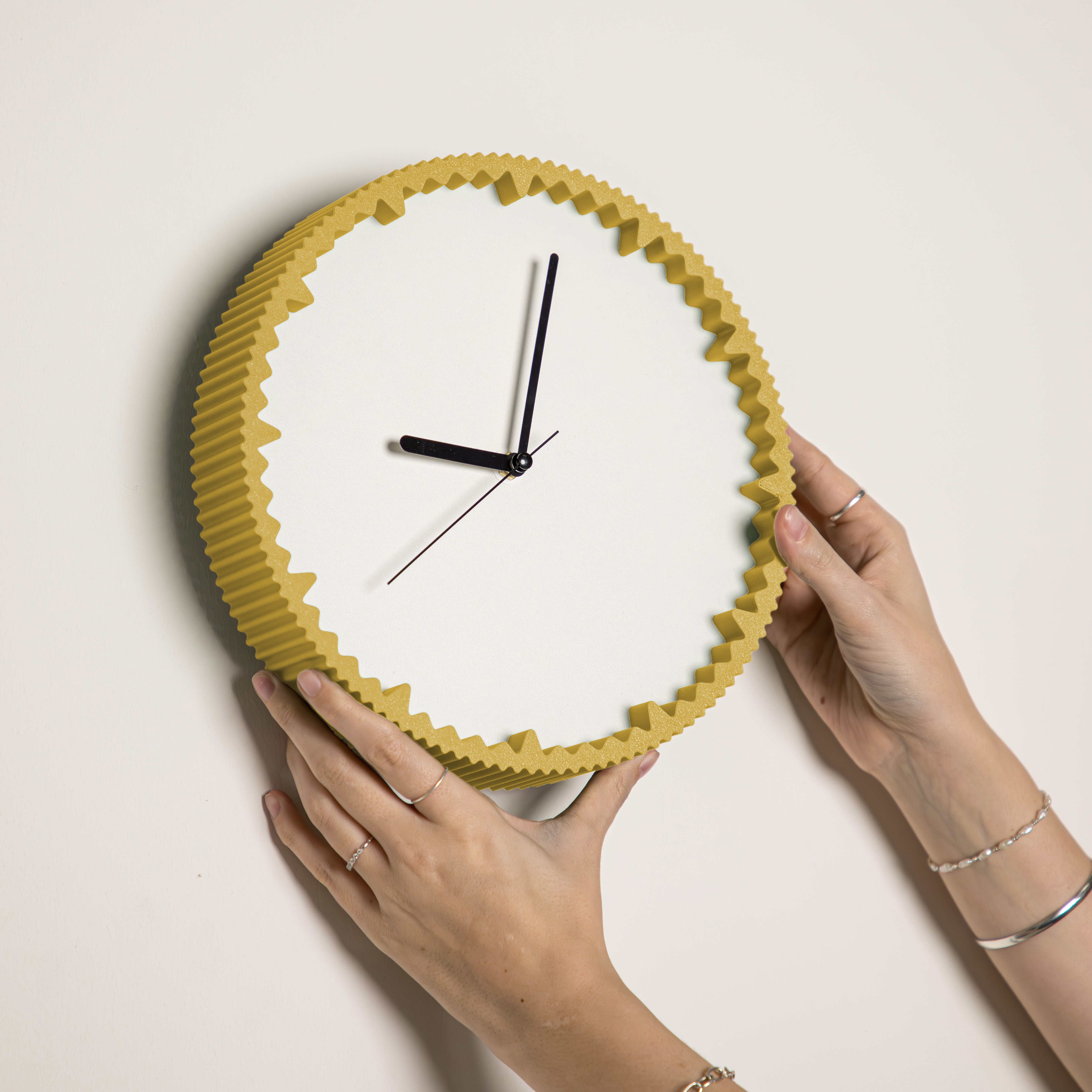 Hände hängen moderne Wanduhr senfgelb mit gezacktem Rand aus dem 3D Druck an die Wand #farbe_senfgelb