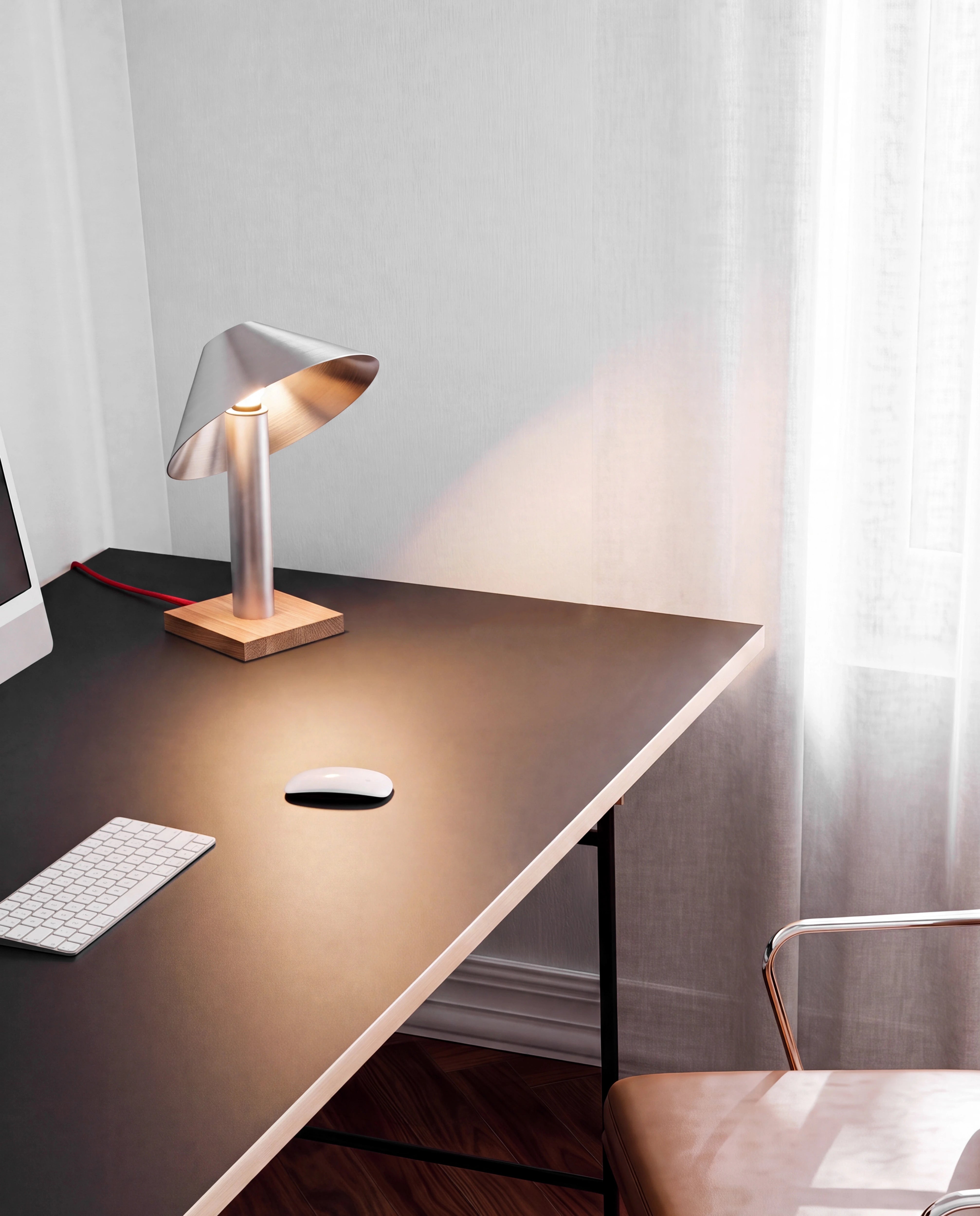 Geschwenkte Tischleuchte PFEIL auf dunklem Schreibtisch, Lichtkegel auf der Arbeitsfläche