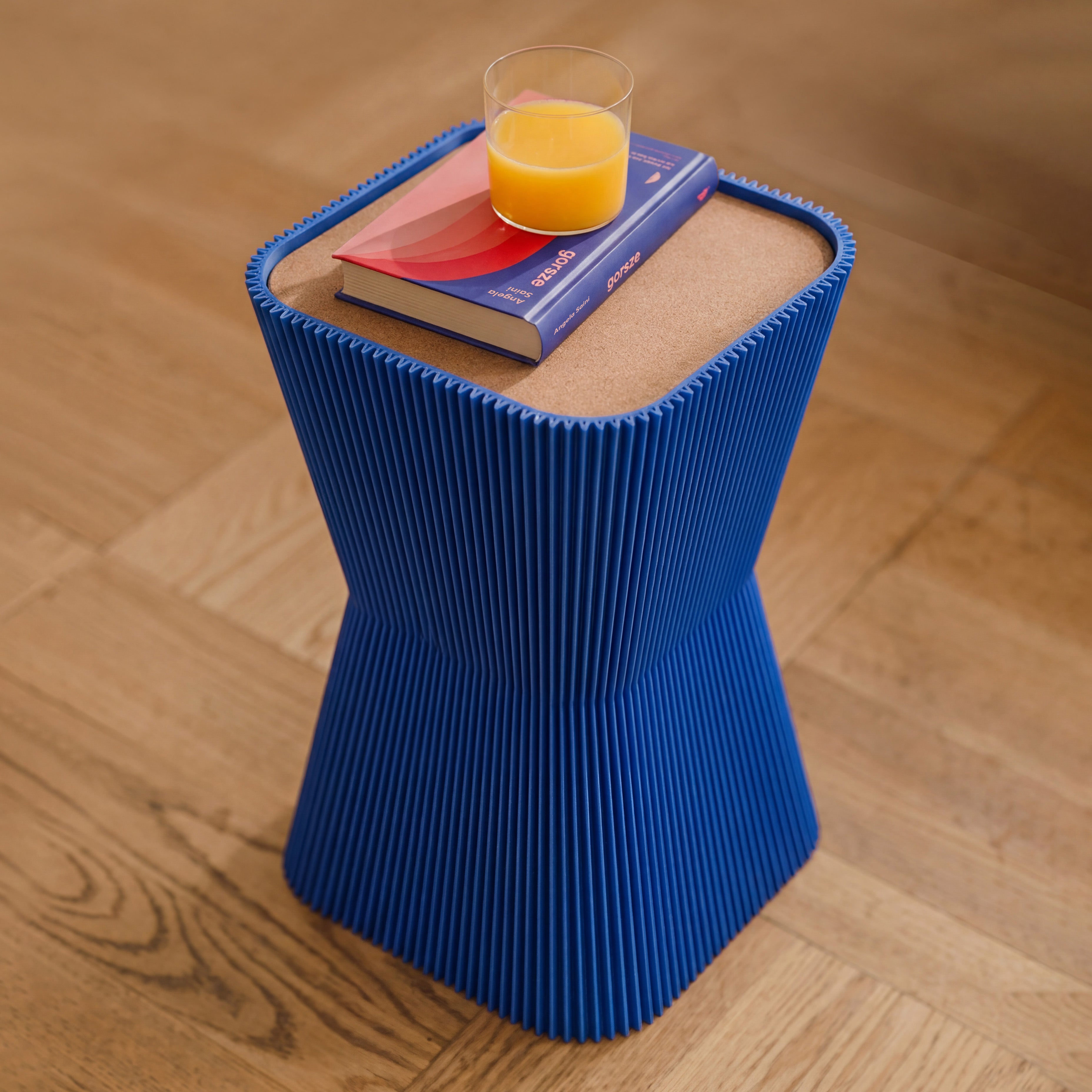 Beistelltisch Pyramide in blau aus dem 3D Druck mit Buch und Orangensaft auf dem Korkdeckel #farbe_blau