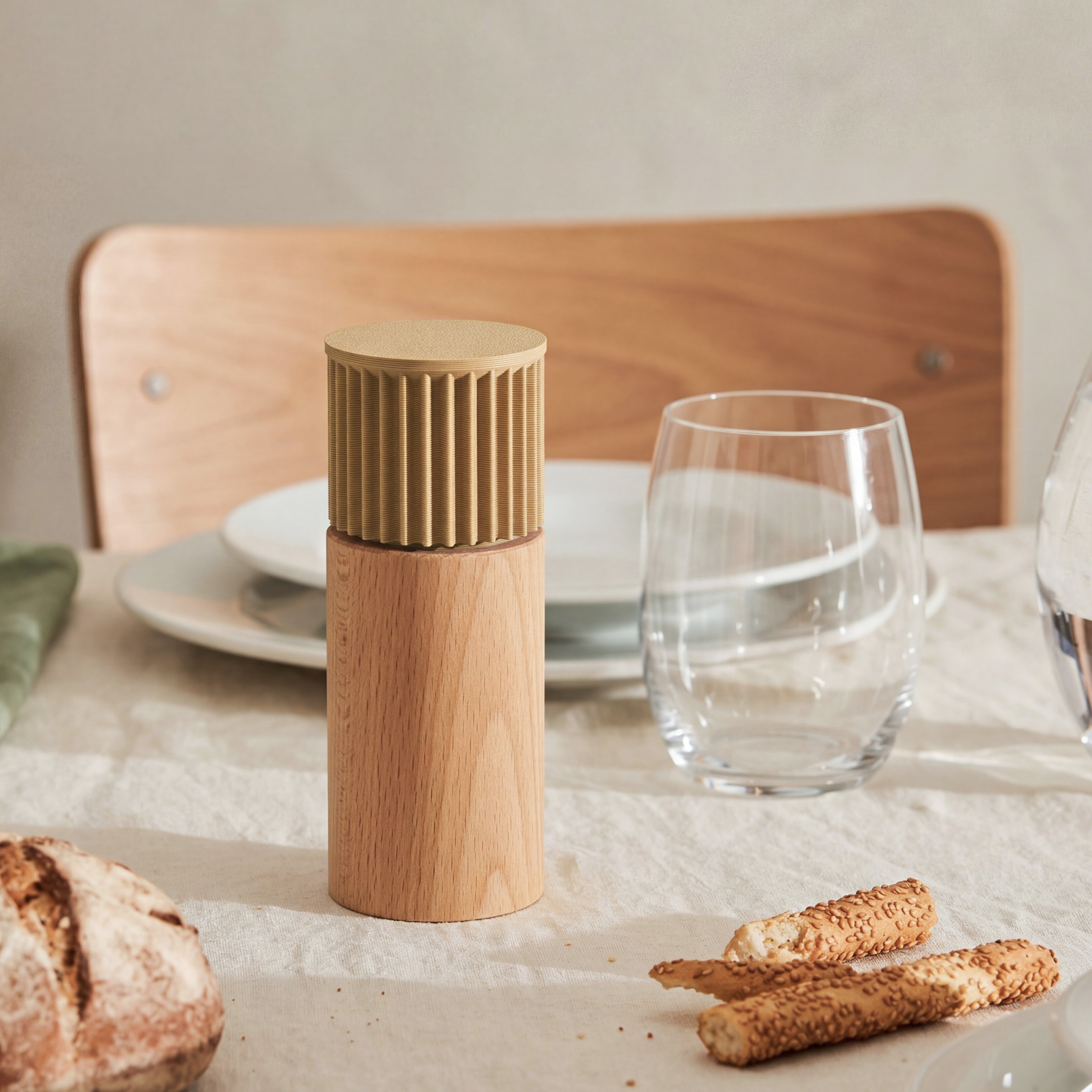 Gewürzmühle Prise in beige aus Buchenholz auf gedecktem Tisch mit Brot und Wasserglas #farbe_beige