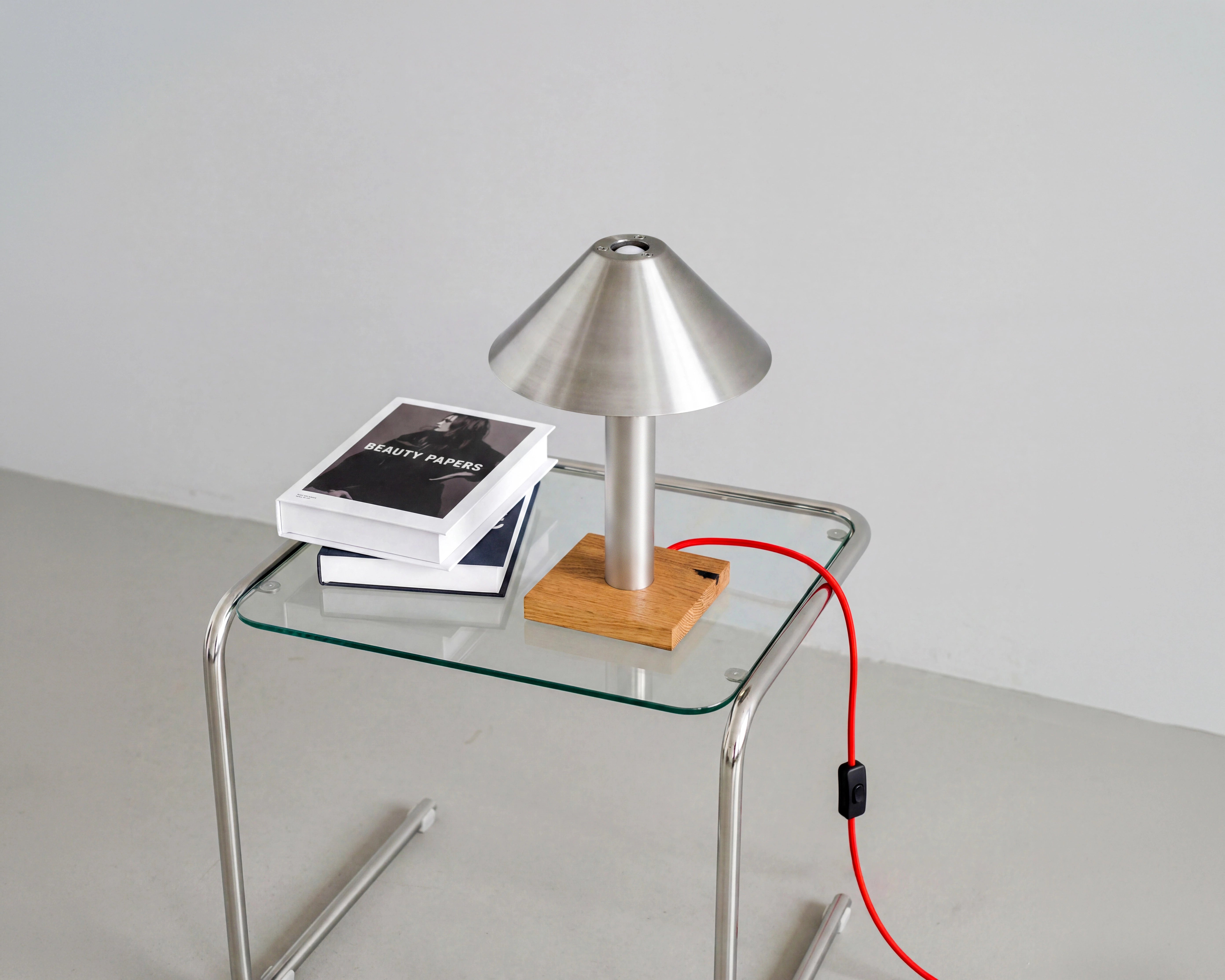 Tischlampe PFEIL in Aufsicht mit Blick in die Schirmöffnung, Eichensockel auf verchromtem Glastisch