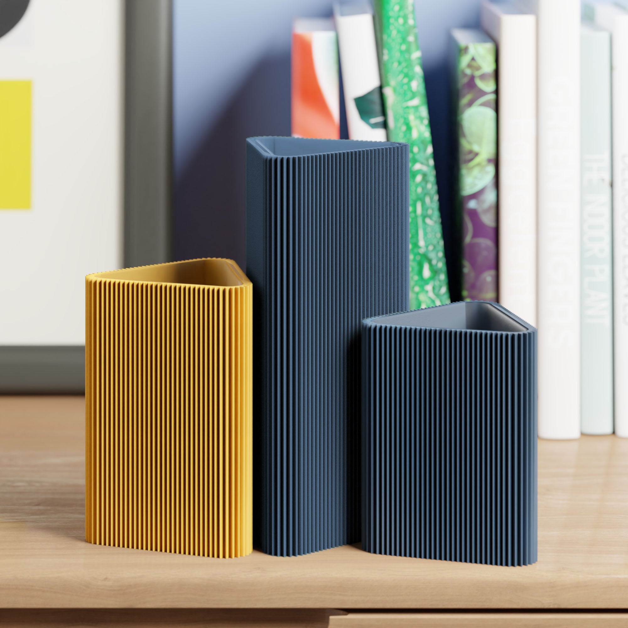 Geometrische Vase DREIECK in navyblau mit zwei weiteren Vasen vor Büchern im Regal #farbe_navyblau