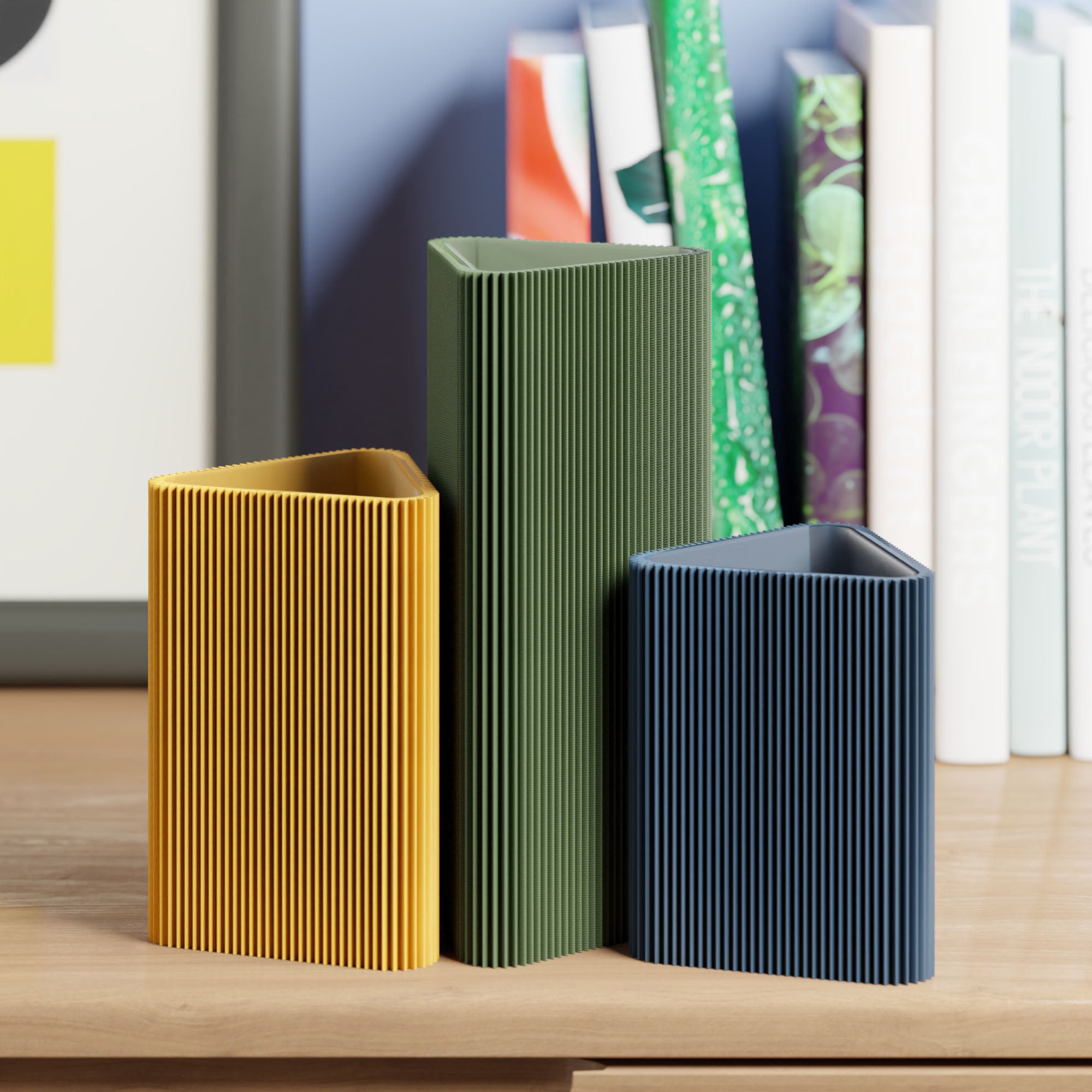 Geometrische Vase DREIECK in Olivgrün mit zwei weiteren Vasen vor Büchern im Regal #farbe_olivgrün