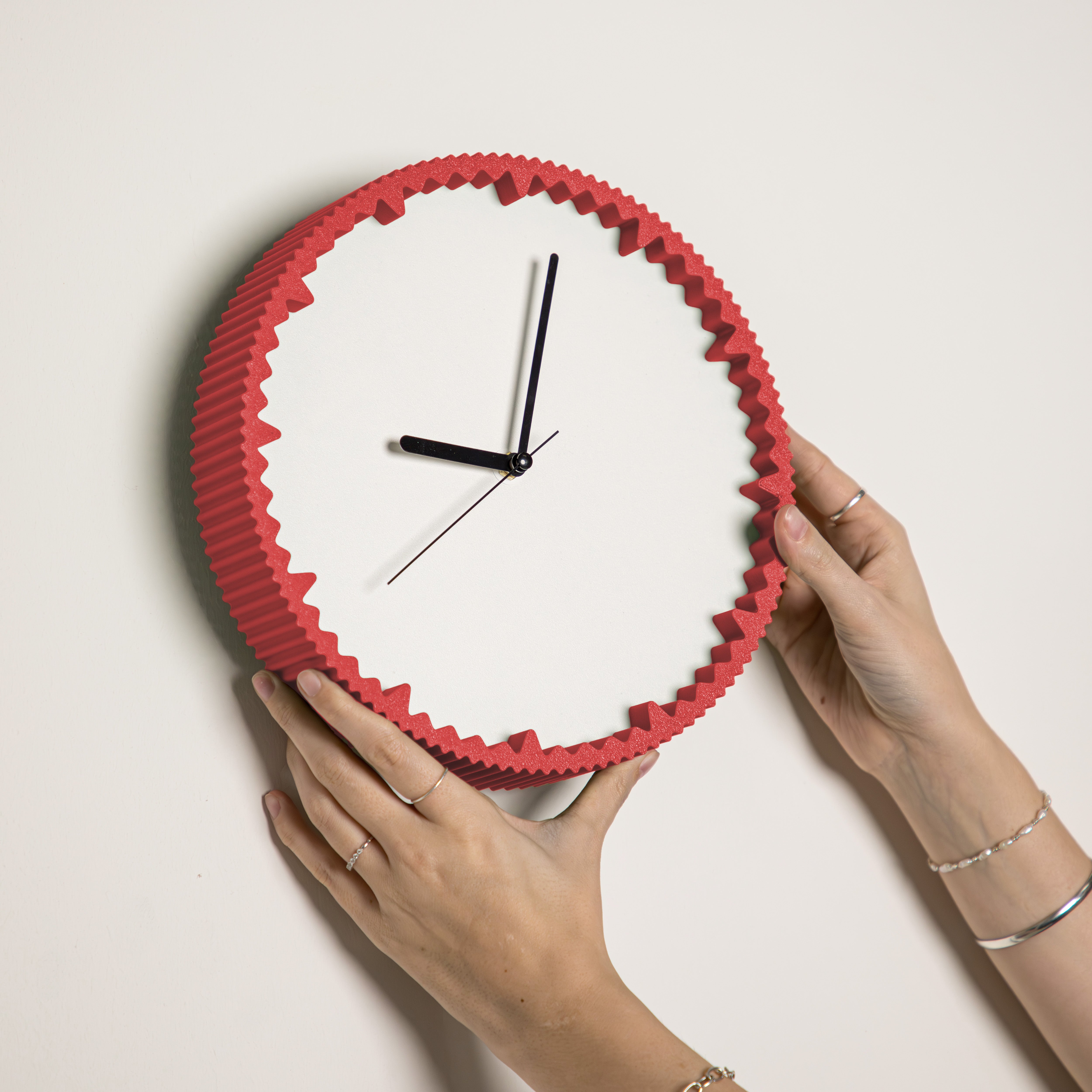 Hände hängen moderne rot Wanduhr mit gezacktem Rand aus dem 3D Druck an die Wand #farbe_rot