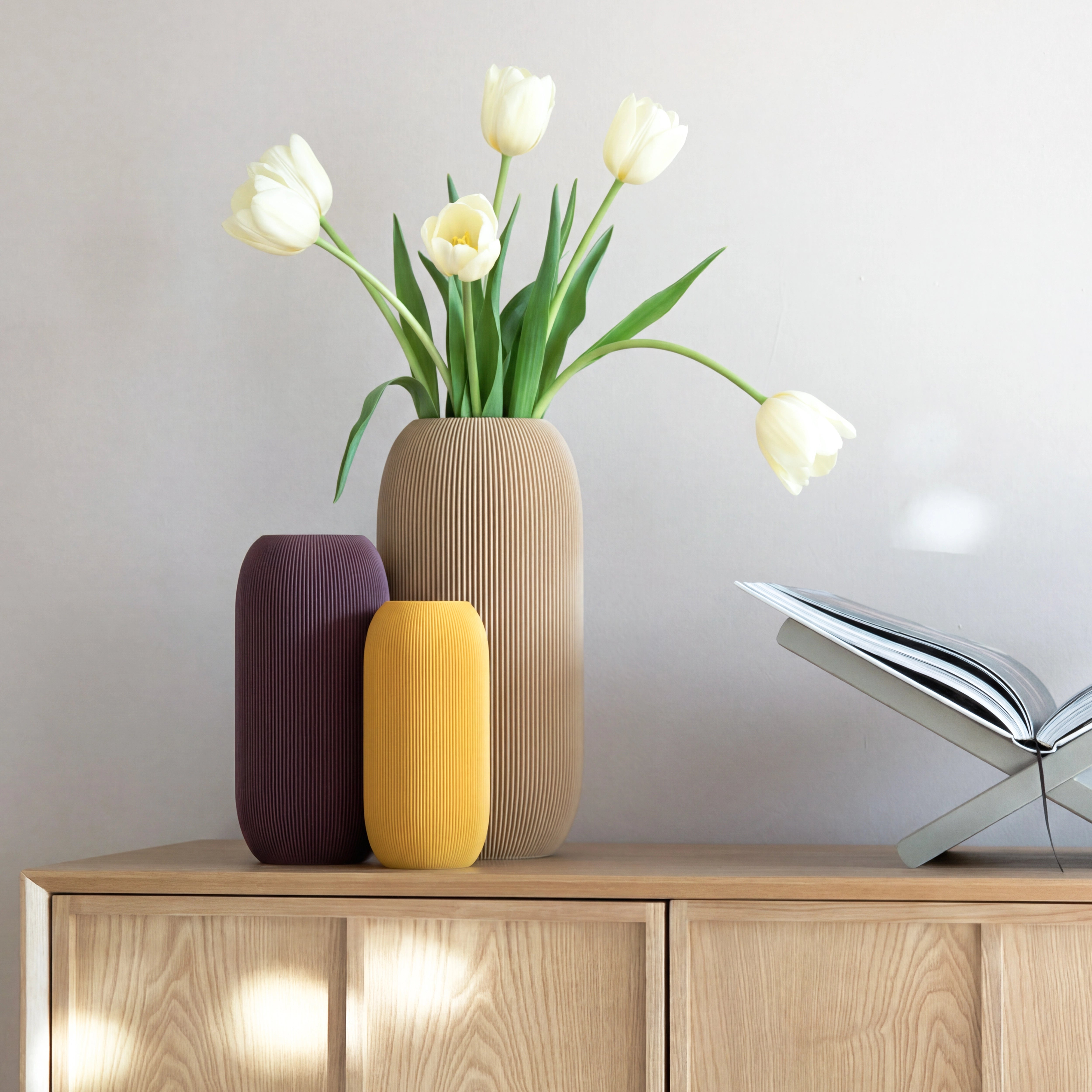 Drei Vasen PILLE aus 3D Druck in Pflaume, Senfgelb und Beige mit Tulpen auf Sideboard